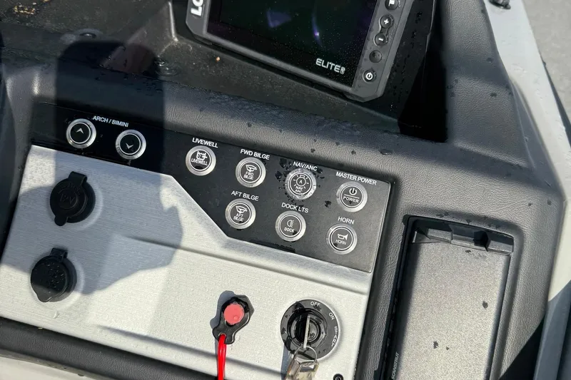 Slide: The Image of Control panel of a 2026 Berkshire 23CL STS boat with various switches and a display. - 13