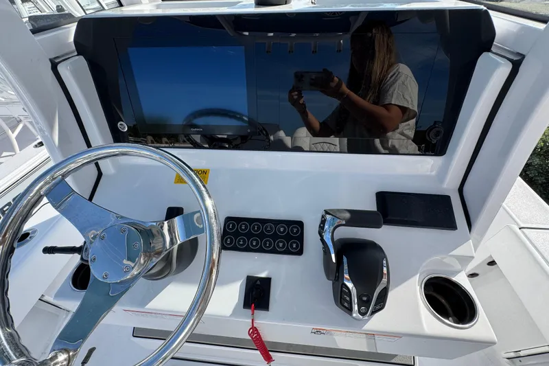 Slide: The Image of 2026 Sportsman Masters 227 Bay Boat dashboard with steering wheel and controls. - 10