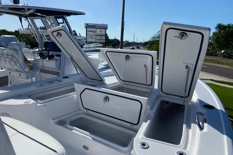 Slide: The Image of 2026 Sportsman Masters 227 Bay Boat with open storage compartments at Thunder Marine dealership. - 19