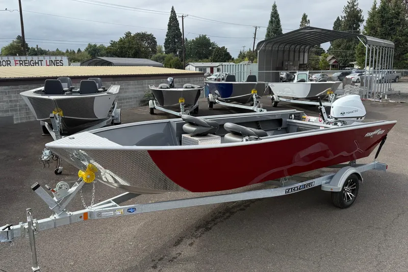 Slide: The Image of 2026 Fish Rite Angler 18 boat in red, parked on a trailer in a lot. - 28