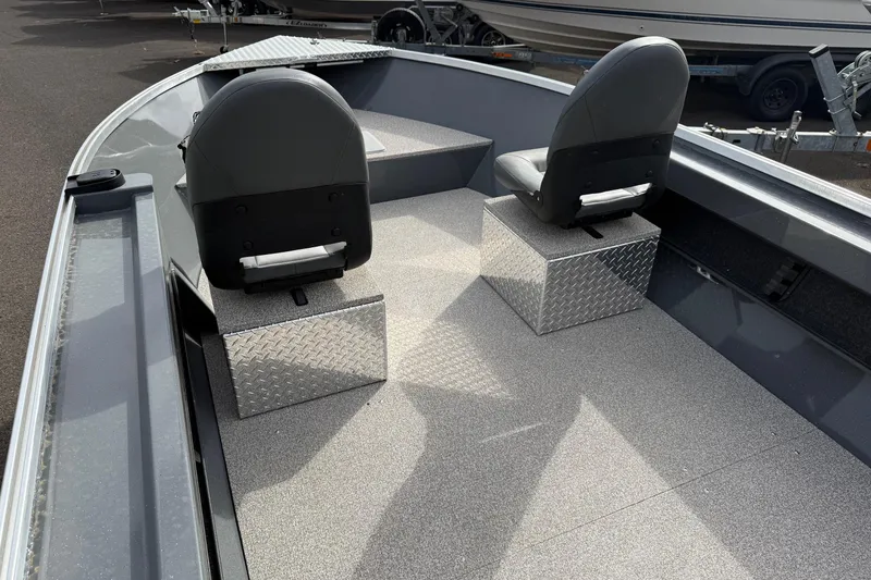 Slide: The Image of 2026 Fish Rite Angler 18 boat interior with two seats and diamond plate flooring. - 9