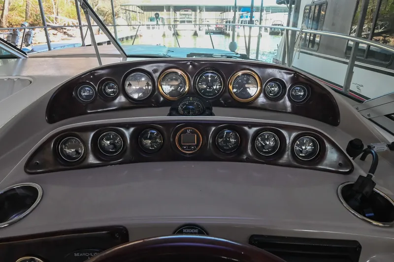 Slide: The Image of Dashboard of a 2000 Rinker Fiesta Vee 330 boat with multiple gauges and controls. - 17