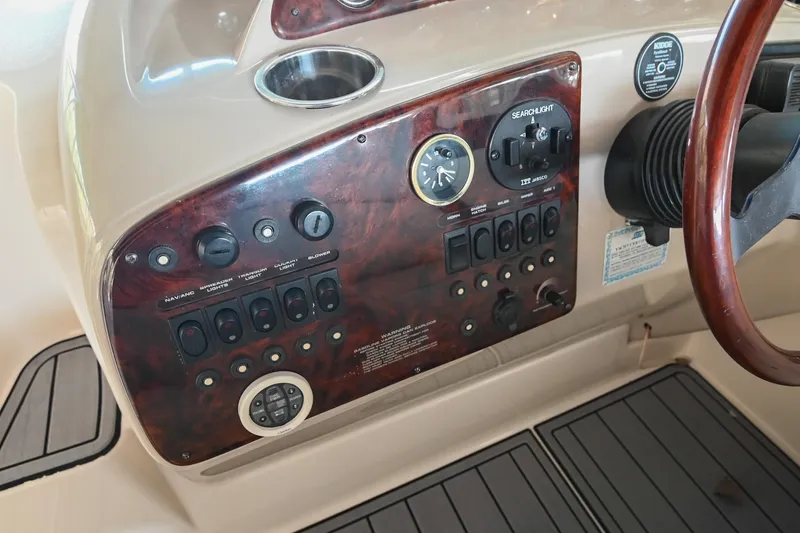 Slide: The Image of 2000 Rinker Fiesta Vee 330 dashboard with controls and wood paneling. - 18