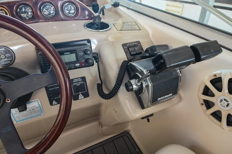 Slide: The Image of Control panel of a 2000 Rinker Fiesta Vee 330 boat, featuring steering wheel and gauges. - 19