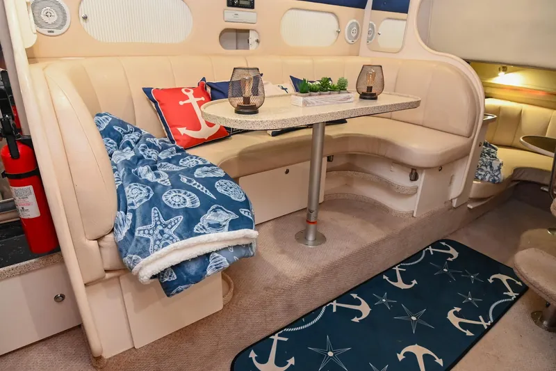 Slide: The Image of Interior of 2000 Rinker Fiesta Vee 330 with nautical-themed decor and cozy seating area. - 24