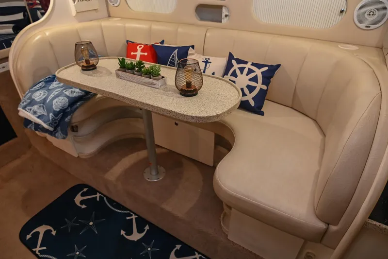Slide: The Image of Interior of 2000 Rinker Fiesta Vee 330 with nautical-themed decor and cozy seating area. - 25