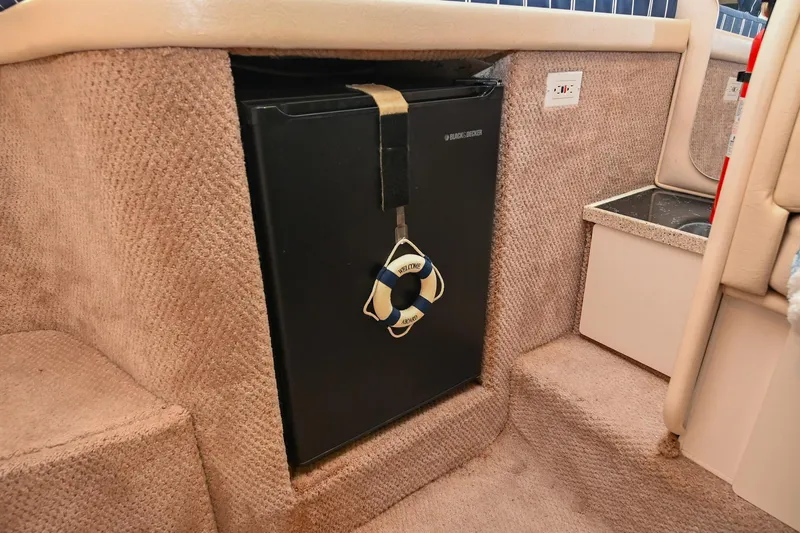 Slide: The Image of 2000 Rinker Fiesta Vee 330 interior with compact fridge and beige carpeted steps. - 31