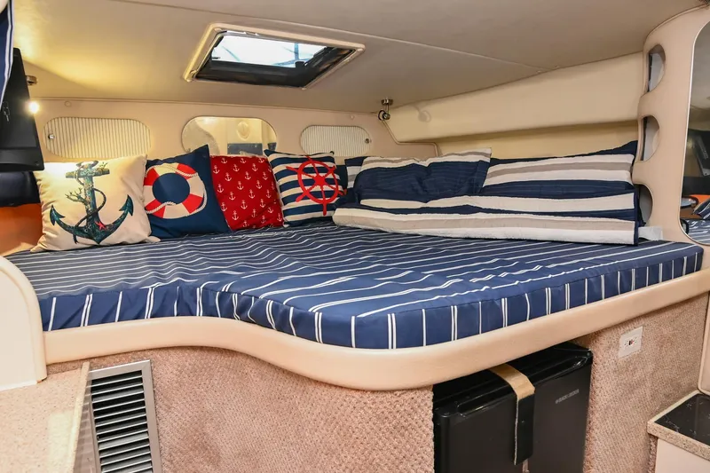 Slide: The Image of Interior of 2000 Rinker Fiesta Vee 330 with nautical-themed bedding and cushions. - 32