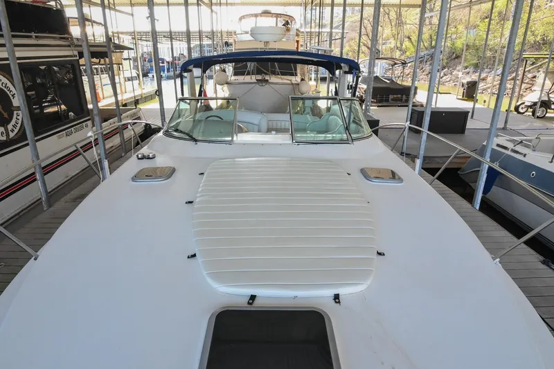 Slide: The Image of 2000 Rinker Fiesta Vee 330 boat docked in a marina, showcasing spacious deck. - 44