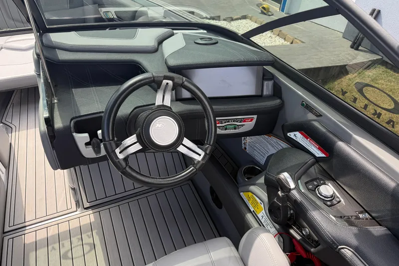 Slide: The Image of 2018 Nautique Super Air Nautique G23 boat dashboard with steering wheel and controls. - 16