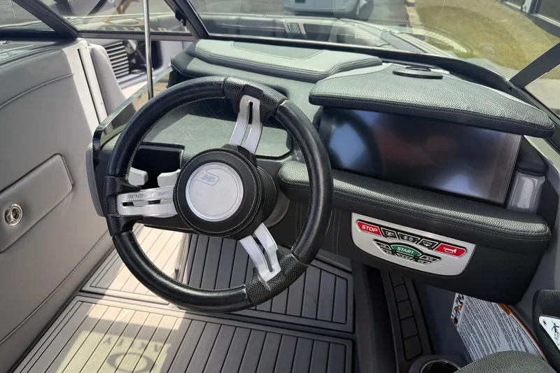 Slide: The Image of 2018 Nautique Super Air Nautique G23 dashboard with steering wheel and control panel. - 18
