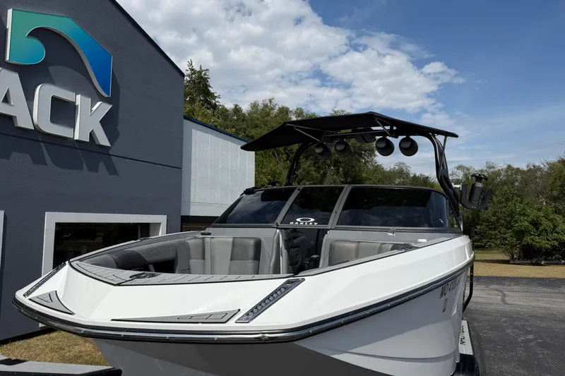 Slide: The Image of 2018 Nautique Super Air Nautique G23 boat parked outside dealership under blue sky. - 3
