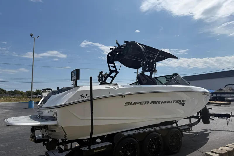 Slide: The Image of 2018 Nautique Super Air Nautique G23 boat on trailer under clear sky. - 7