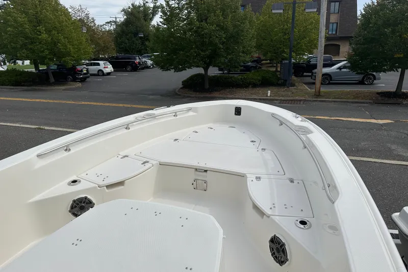Slide: The Image of 2026 Boston Whaler 250 Dauntless boat interior, parked near trees and cars. - 8
