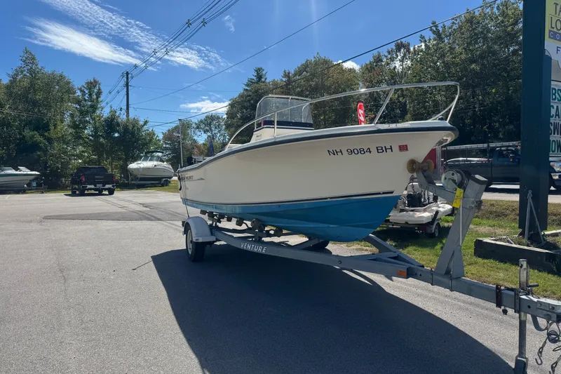 The Image of 2002 Seahunt Triton 202 boat on trailer in sunny outdoor setting. - 0