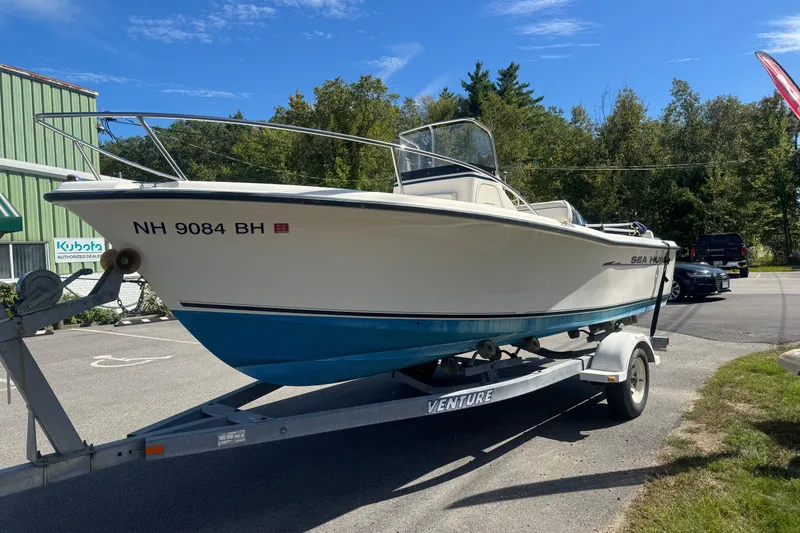 Slide: The Image of 2002 Seahunt Triton 202 boat on trailer, parked outdoors under clear blue sky. - 3