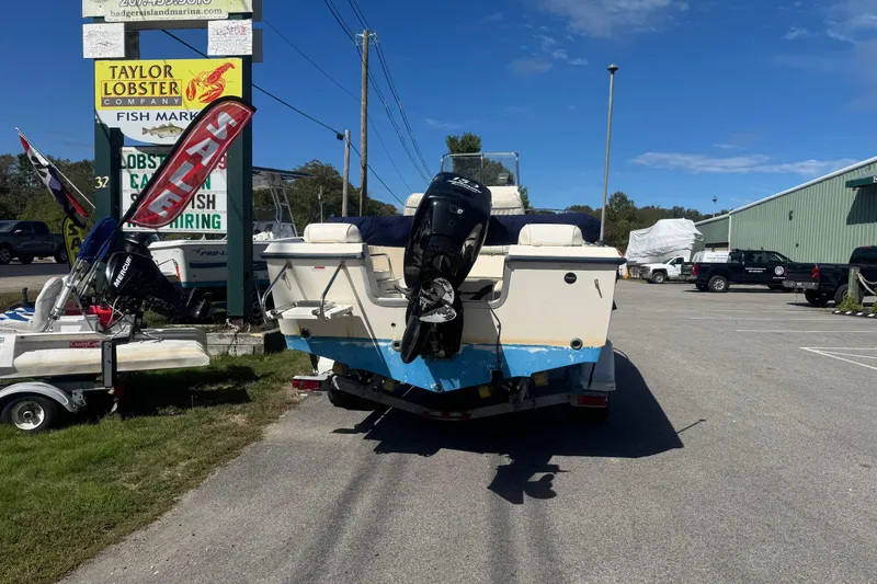 Slide: The Image of 2002 Seahunt Triton 202 boat with outboard motor parked near Taylor Lobster Company. - 4
