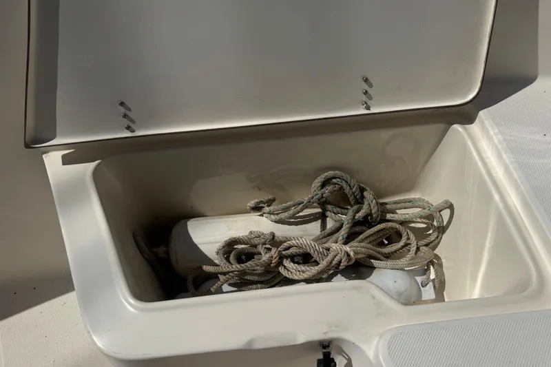 Slide: The Image of Open storage compartment on 2002 Seahunt Triton 202 boat with rope and fender inside. - 6