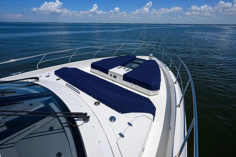 Slide: The Image of 2018 Cruisers 60 Cantius Fly yacht with blue sun pads on open water. - 15