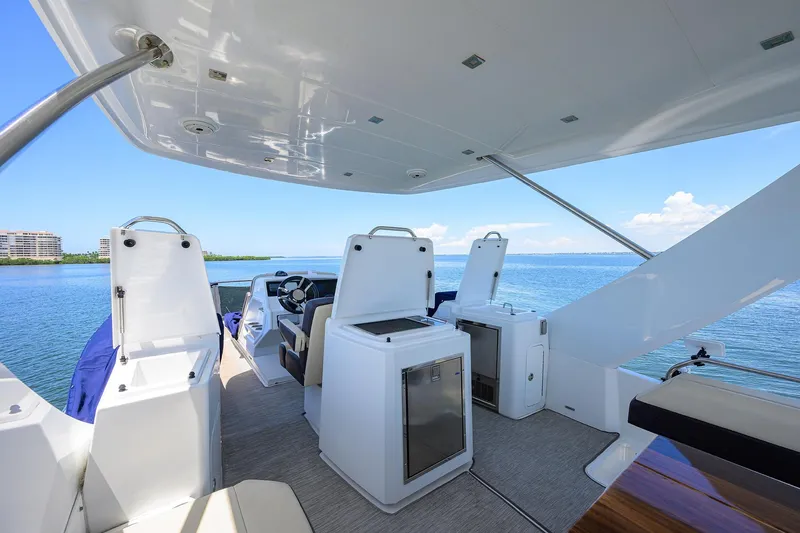 Slide: The Image of 2018 Cruisers 60 Cantius Fly yacht interior with ocean view, featuring modern helm and seating. - 19