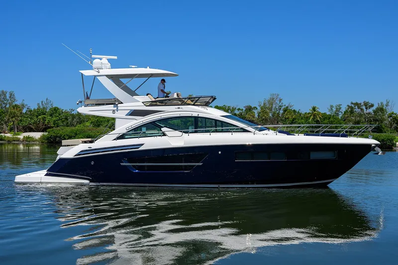 The Image of 2018 Cruisers 60 Cantius Fly yacht on calm water, clear blue sky background. - 1
