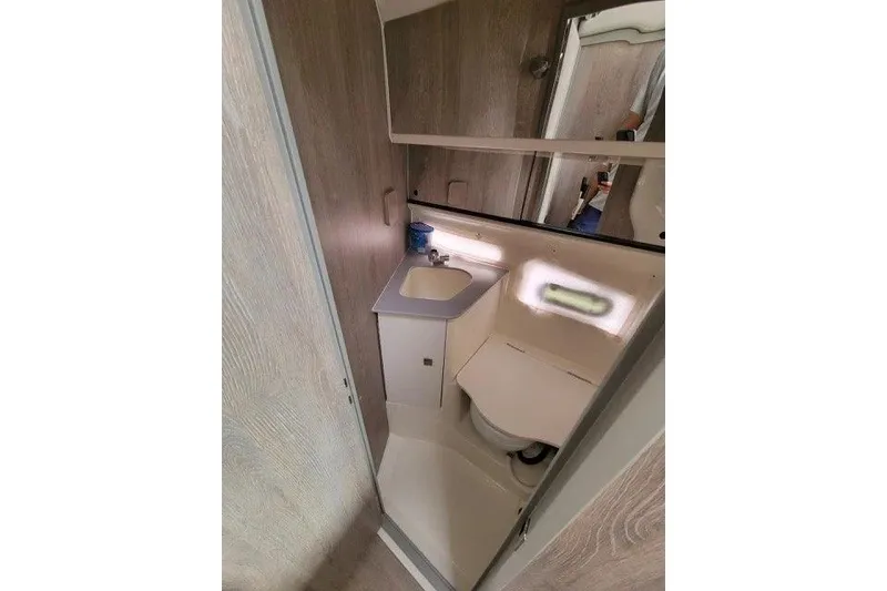 Slide: The Image of 2024 Bayliner Trophy T29 Explorer bathroom with sink, toilet, and mirror. - 10