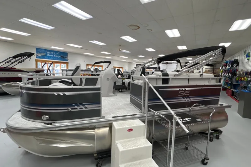 Slide: The Image of 2025 South Bay 16 FC SE pontoon boat displayed in showroom with accessories. - 16
