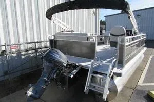 Slide: The Image of 2025 South Bay 16 FC SE pontoon boat with outboard motor and canopy, parked outdoors. - 3