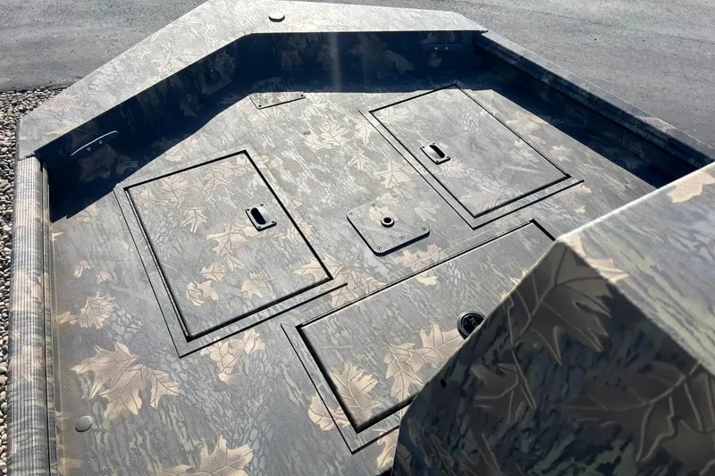 Slide: The Image of 2025 Crestliner 1660 Retriever FCC boat deck with camouflage pattern and storage compartments. - 4