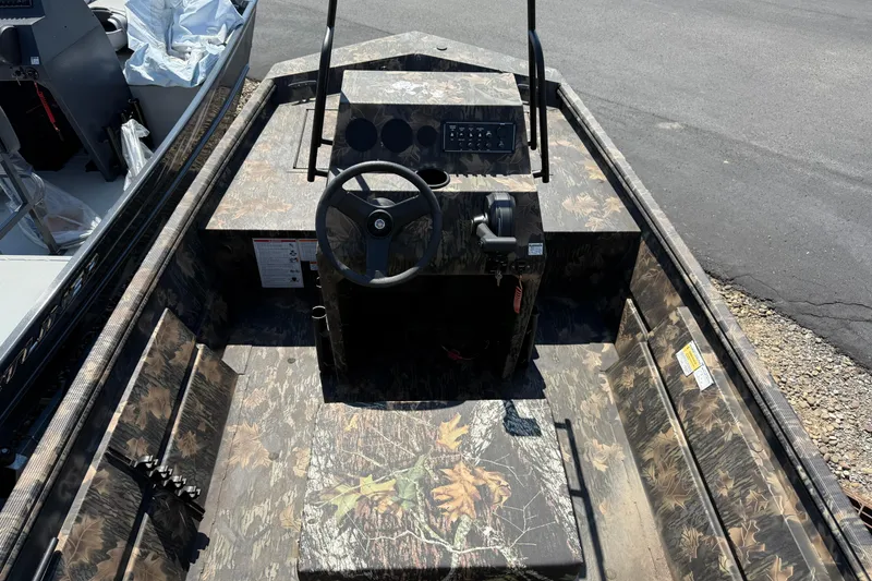 Slide: The Image of 2025 Crestliner 1660 Retriever FCC boat interior with camouflage design and steering console. - 6