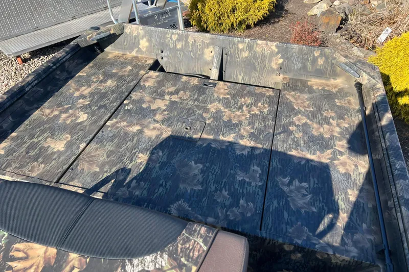 Slide: The Image of 2025 Crestliner 1660 Retriever FCC boat with camouflage pattern, outdoor setting. - 7