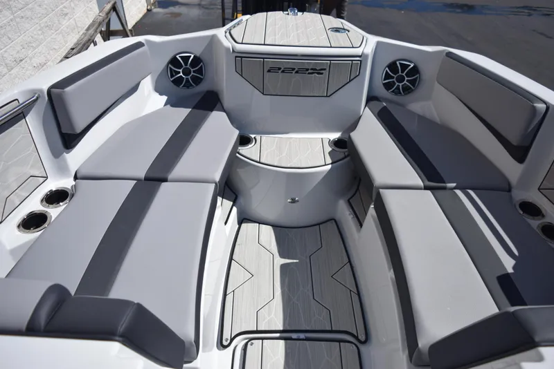 Slide: The Image of 2024 Yamaha Boats 222XD interior seating area with gray cushions and speakers. - 12