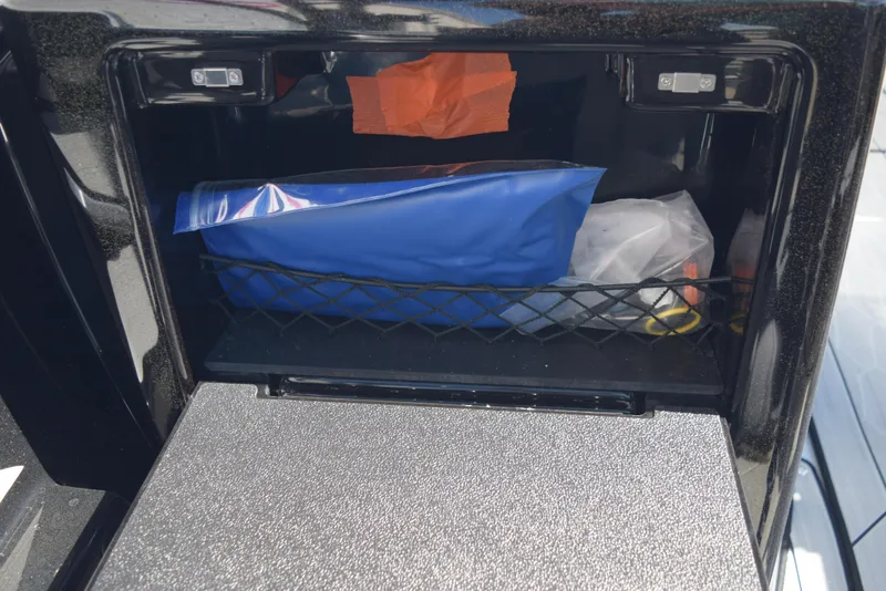 Slide: The Image of Storage compartment of 2024 Yamaha Boats 222XD with various items inside. - 24