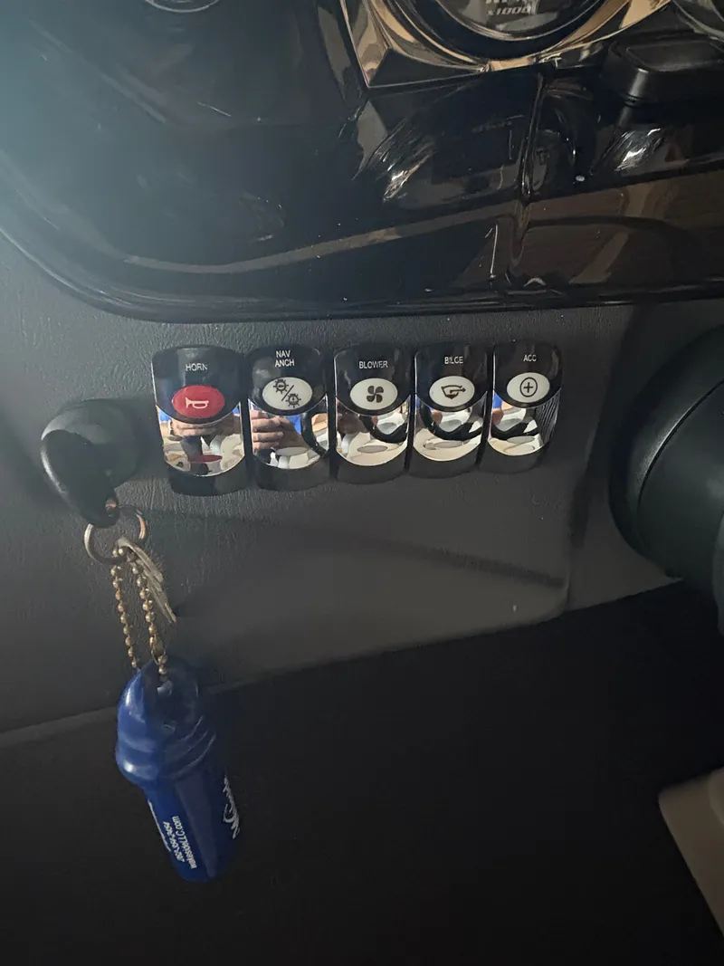 Slide: The Image of Control panel of a 2014 Tigé R20 boat with labeled switches and keychain. - 10