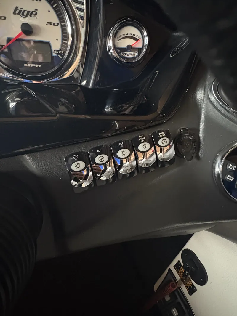 Slide: The Image of Dashboard controls of a 2014 Tigé R20 boat with speedometer and switches. - 11