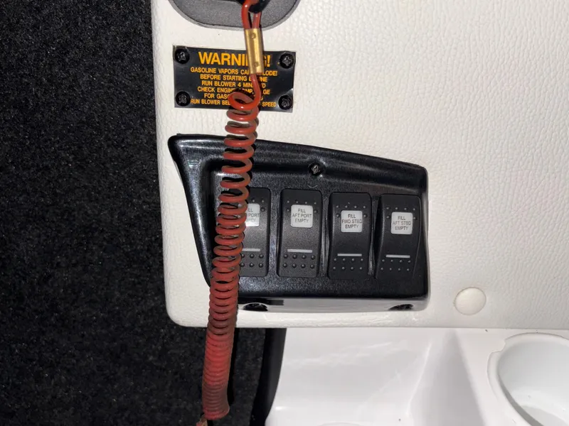 Slide: The Image of Control panel of a 2014 Tigé R20 boat with warning label and switches. - 12