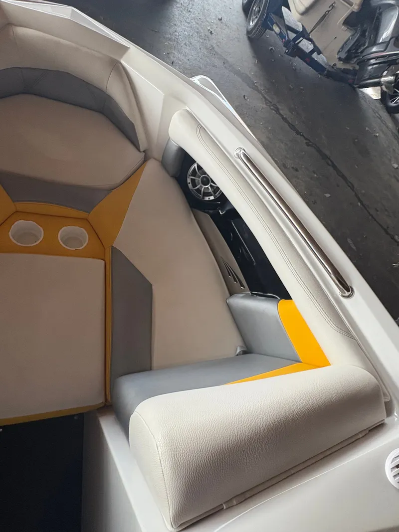 Slide: The Image of 2014 Tigé R20 boat interior with gray and yellow seating, cup holders, and sleek design. - 15