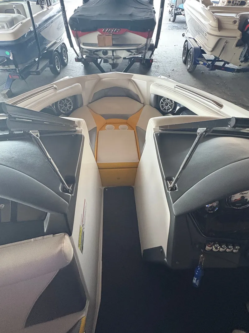 Slide: The Image of 2014 Tigé R20 boat interior with seating and cup holders in a showroom. - 16