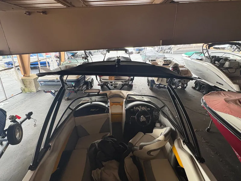 Slide: The Image of 2014 Tigé R20 boat interior in storage, surrounded by other boats. - 17