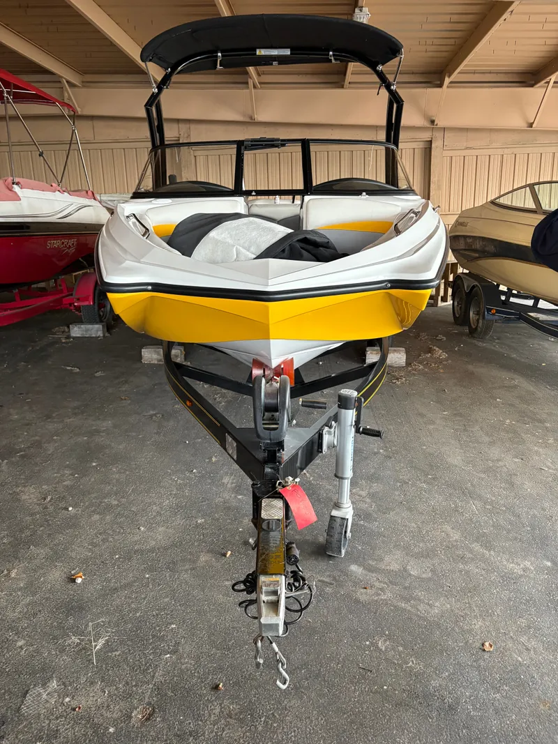 Slide: The Image of 2014 Tigé R20 boat with yellow hull on a trailer in a garage. - 2