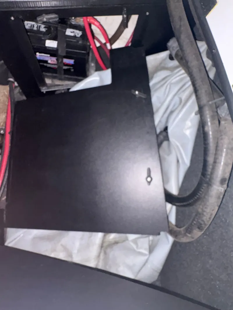 Slide: The Image of 2014 Tigé R20 boat battery compartment with cables and cover. - 21