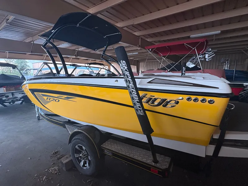 Slide: The Image of 2014 Tigé R20 yellow boat with black accents in a storage facility. - 4