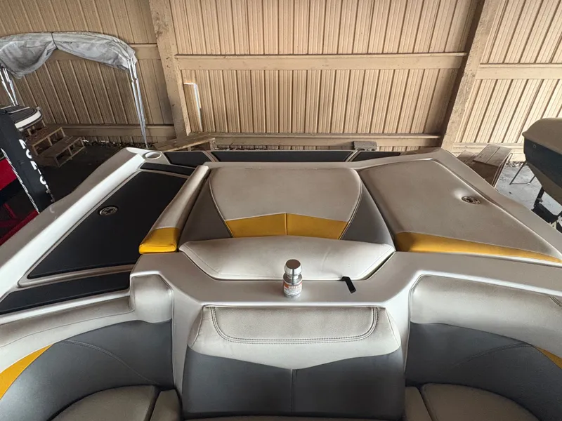 Slide: The Image of 2014 Tigé R20 boat interior with beige and yellow upholstery in a storage facility. - 8