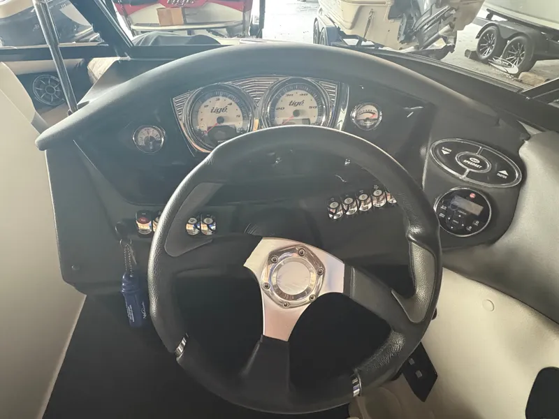 Slide: The Image of 2014 Tigé R20 boat dashboard with steering wheel and control gauges. - 9