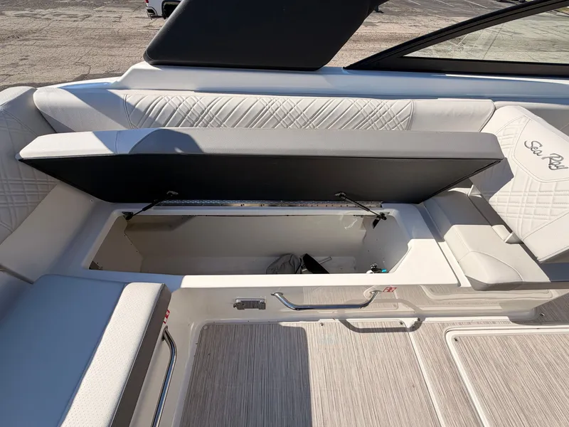 Slide: The Image of The image shows the seating area of a Sea Ray SDX 270 boat with open storage. - 28