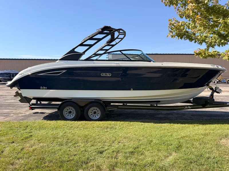 Slide: The Image of A 2026 Sea Ray SDX 270 boat on a trailer, featuring a blue hull and black wakeboard tower. - 9