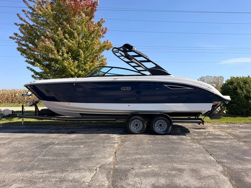 Slide: The Image of A 2026 Sea Ray SDX 270 on a trailer. The hull is dark blue with white accents. - 2