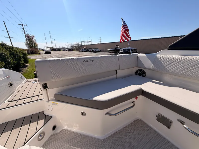 Slide: The Image of The 2026 Sea Ray SDX 270 features an elegant, cushioned bench seat with an American flag pole. - 19
