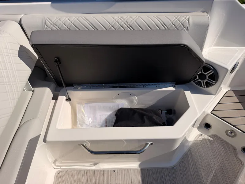 Slide: The Image of An open storage compartment on a Sea Ray SDX 270 boat with gray upholstery. - 30