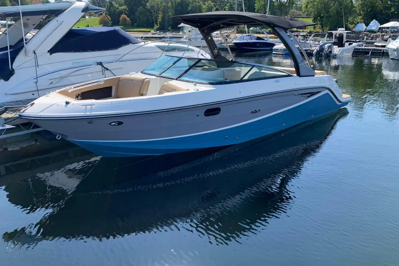 The Image of 2023 Sea Ray SLX 280 boat docked in a marina, featuring sleek design and blue hull. - 0